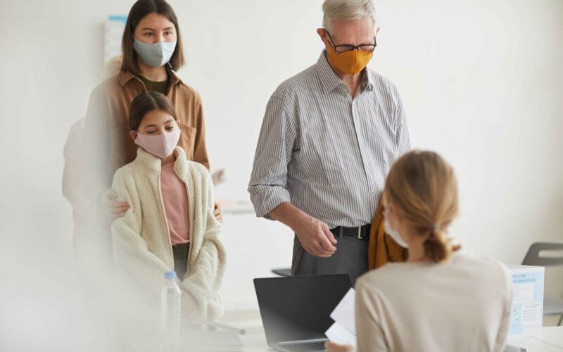 Wide angle portrait of modern senior man registering for covid vaccine in medical clinic, copy space